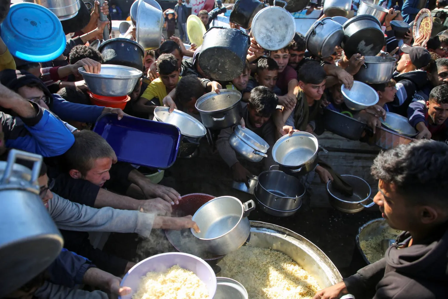فلسطينيون يتجمعون لتلقي مساعدات الطعام وسط أزمة الجوع مع استمرار العدوان الصهيوني بغزة
