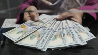 أوراق من الدولار الأميركي لدى محل صرافة (أ.ب)