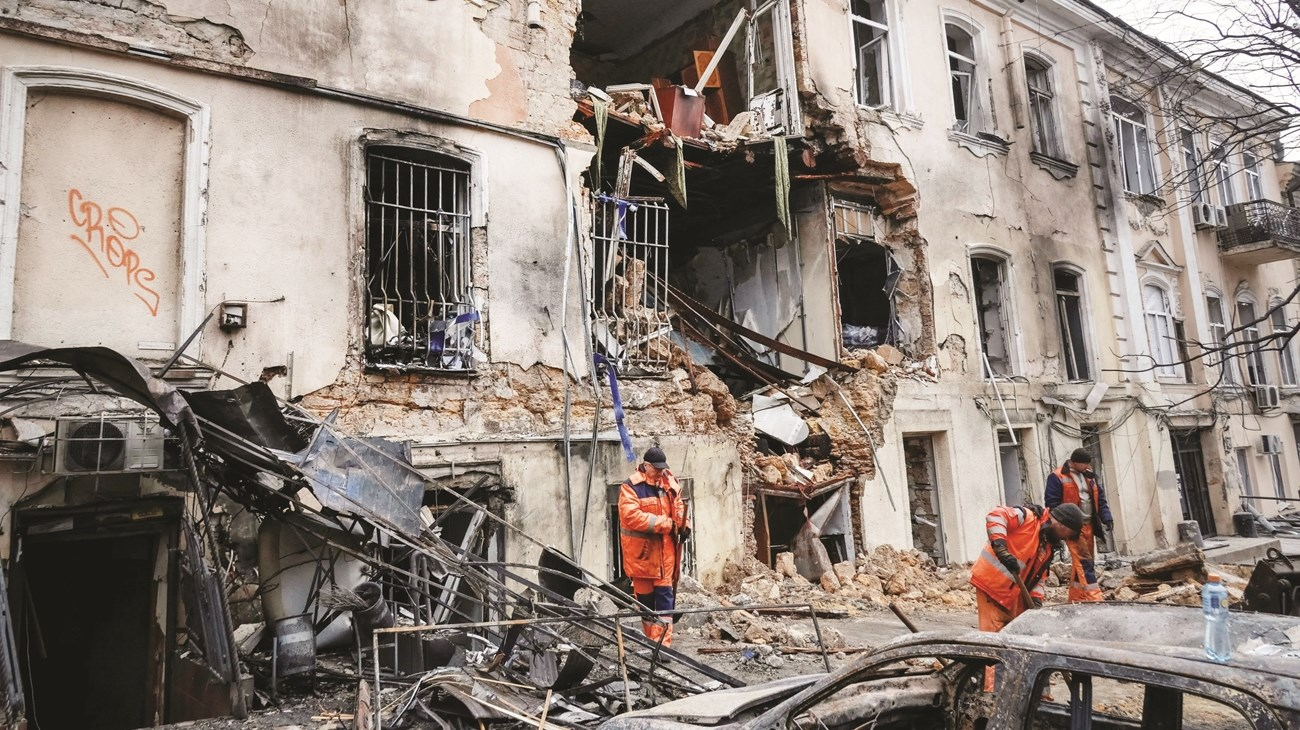 عمال نظافة في موقع مبنى سكني تعرض لغارة روسية (رويترز)